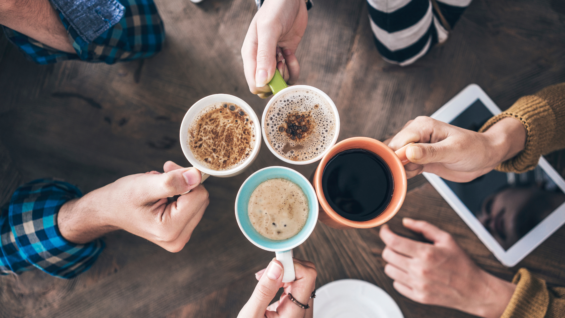 Coffee cups held by hands in a group