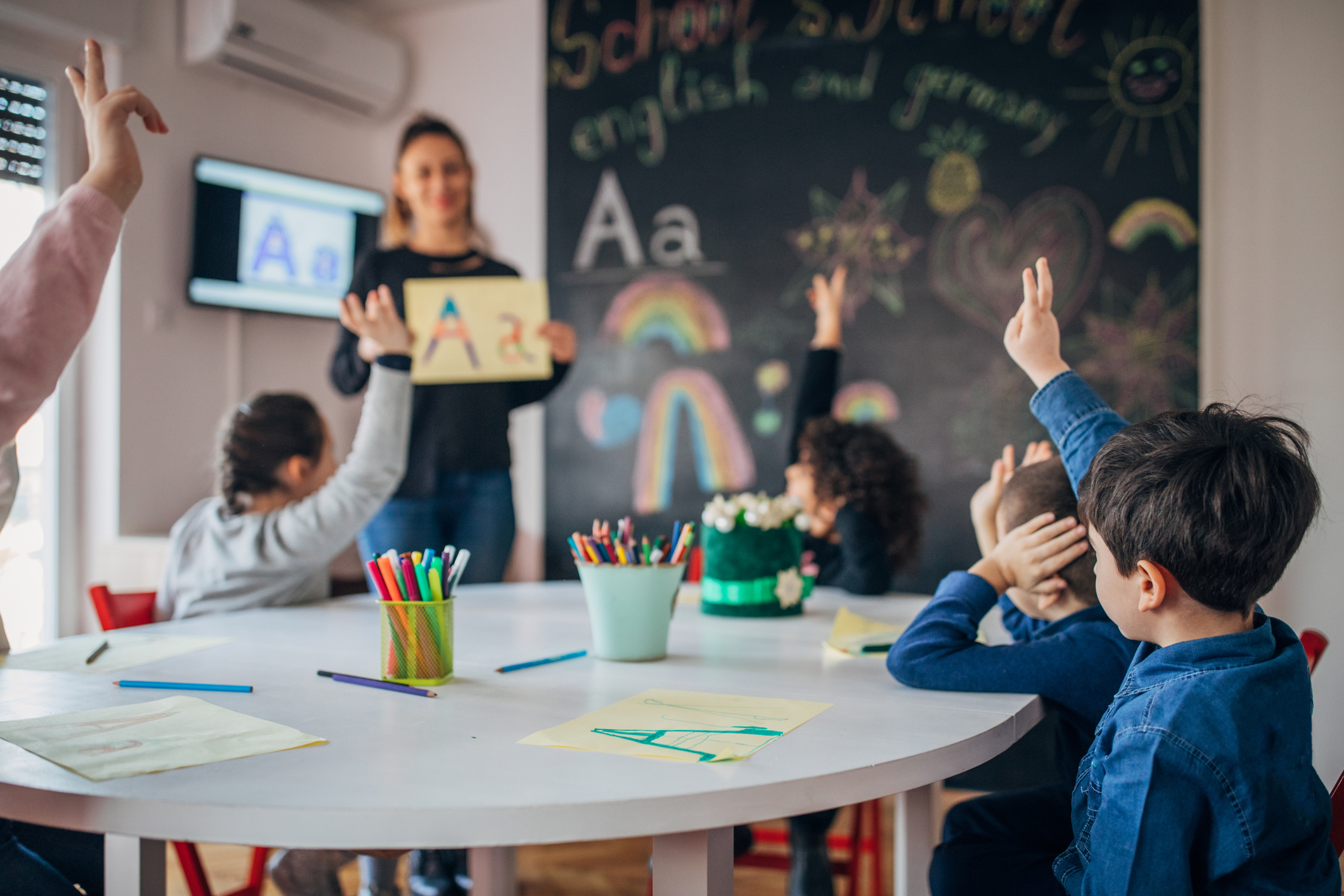 Teacher holding a sign in front of the class of small children