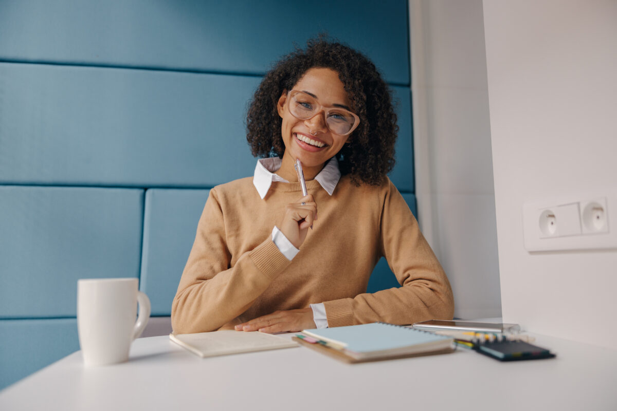 Female manager looks camera with smile while sitting in cozy coworking