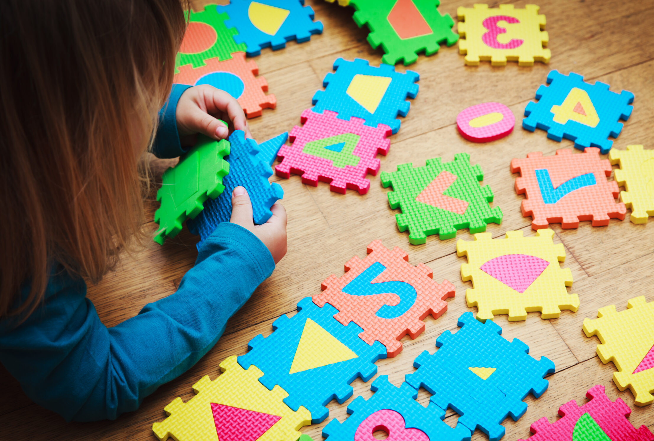 little girl playing with puzzle, early education concept